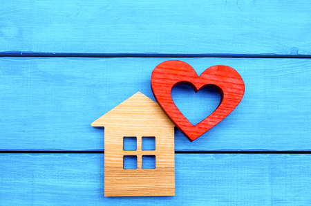 wooden house and red heart on a blue wooden backgroundの写真素材