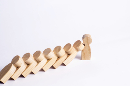 People in line fall like dominoes. Man stops the fall of people as dominoes. The concept of durability and strength, business ideas. Willpower, strong nerves, strong character. Stubbornness.の写真素材
