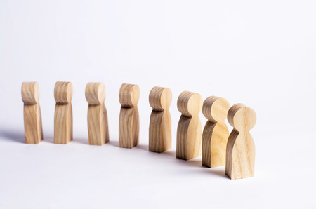People stand in line at the briefing and wait for orders. Wooden figures of people are waiting in line. Concept of business, army, sports team. People listen to a mentor on a white background.の写真素材