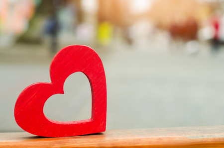 model of a red wooden heart outdoors. concept of love, romance, date. waiting for a meeting. The first meeting. place for text

の写真素材