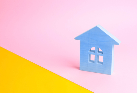 Blue wooden house on a pink background in pop style. The concept of renting, selling and buying a home. Juicy colors and fresh colors. Real estate market, realtors. Affordable youth housingの写真素材