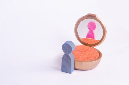 A miniature figure of a man looks in the mirror and sees his hatching in another gender. The concept of gender identity. Transgender, gay lesbian person. Sex education, inequality and gender equalityの写真素材