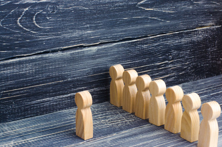 People stand in line at the briefing and wait for orders. Wooden figures of people are waiting in...