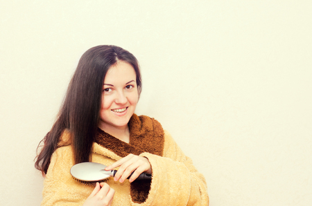 young brunette girl combing her hairの写真素材