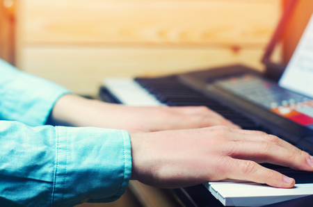 Close-up of a music performer's hand playing the piano, man's hand, classical music, keyboard, synthesizer, pianistの写真素材