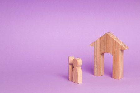 Two people stand near the house and evaluate its qualities before buying. The concept of buying and selling immobility. Parents are waiting at home. Housing for a couple. Rental of propertyの写真素材