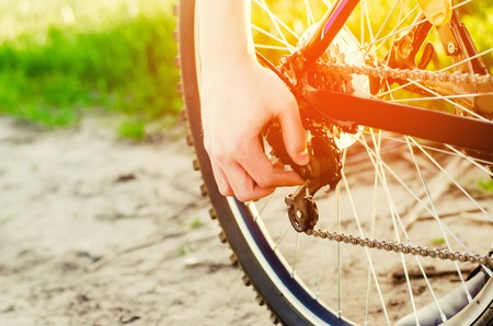 the guy repairs the bicycle. chain repair. cyclist. unratitude on the road, travel, sports, close-up.の写真素材