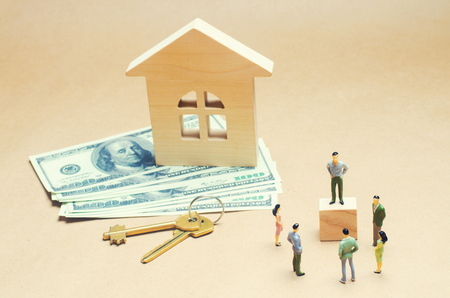 people are standing near a wooden house. concept of real estate. buying and selling an apartment. renting a house. contract signing. affordable housing for young families. loan and mortgageの写真素材