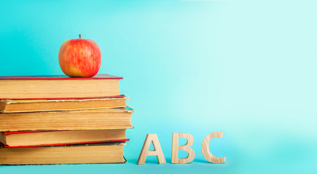 the concept of education. apple, books and alphabe, blue background, place for text, back to school, copy spaceの写真素材