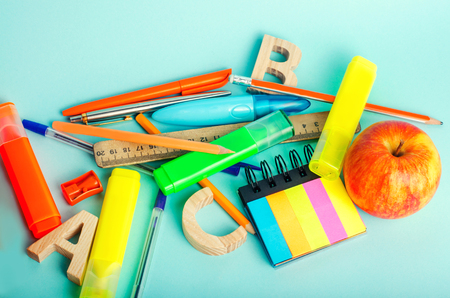 school supplies on a bright blue background, top view, concept of education, creative disorder, desktop, school deskの写真素材