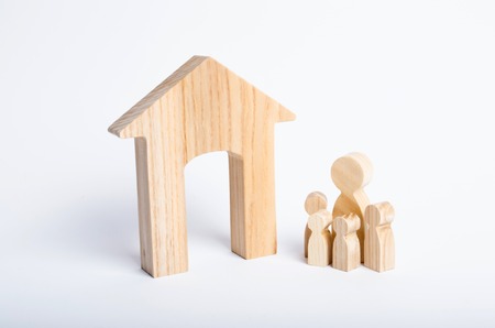 Young parents and a child are standing near their home. Concept of real estate, buying and selling a house. Affordable housing for families. Education and education of young people, investmentの写真素材