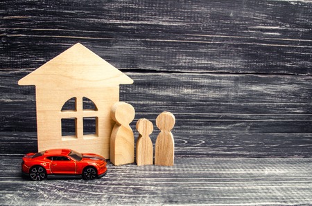 Family, wooden house model and car. Buying and selling or car insurance. Business success. Concept of real estate, buying, renting or selling housingの写真素材