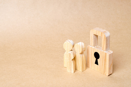 A family with a padlock. Three people with a lock. Security and safety, collateral, loan for a mortgage. Confiscation of property for debts. Safety and alarm system. Security service.の写真素材