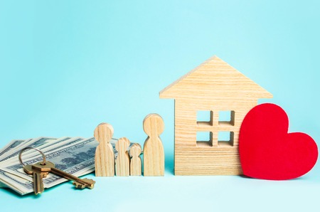 concept of real estate, housing for the family, buying and selling of quarters, apartment rental, mortgage, people figurines, dollars, house and keys on a blue backgroundの写真素材