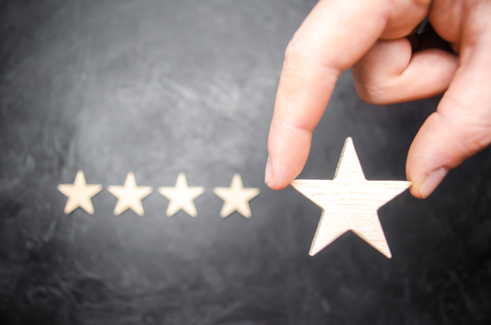 The businessman's hand in the suit holds the fifth star. Get the fifth star.の写真素材