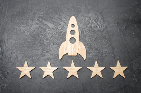 A wooden space rocket and five stars on a concrete background. The concept of space travel, commercial launches into space.の写真素材