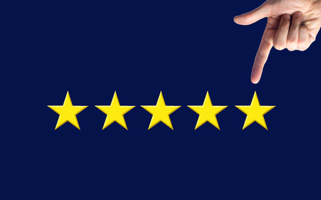A man's hand points to the fifth star. Quality status is five stars. A new star, achievement,...