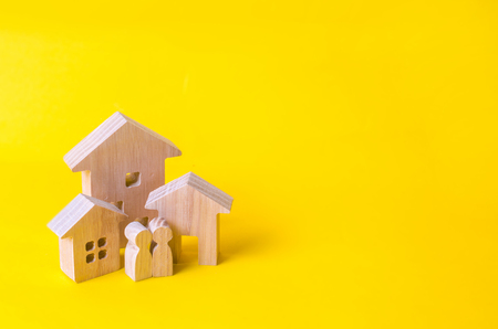 Three houses on a yellow background. Buying and selling of real estate, construction. Apartments and apartments. City, settlement. Minimalism. for presentations. real estate market.の写真素材