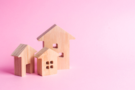 Three houses on a pink background. Buying and selling of real estate, construction. Apartments and apartments. City, settlement. Minimalism. for presentations. real estate market.の写真素材