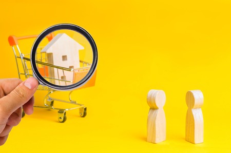 People stand on the background of a wooden house in basket from a supermarket. Concept of real...