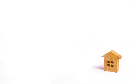 A small wooden house stands on a white background. The concept of buying and selling real estate, renting. Search for a house. Affordable housing, credit and loans. Investments in businessの写真素材