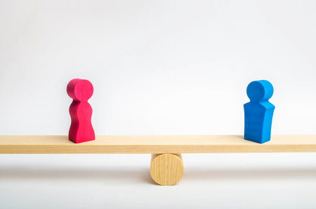 Figures of a man and a woman on the scales. inequality concept : man and women on a weighing balance, gender pay gap. divorce. Division of property in court. Social role in the familyの写真素材