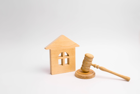 Wooden house and hammer of the judge on a white background. Concept trial property. The court decision on the transfer of property, the nationalization of property. The right to propertyの写真素材