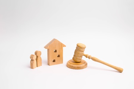Wooden apartment house with people, keys and a judge hammer on a white background. The concept of laws and regulations for tenants and owners of a residential building. Condominiums.の写真素材