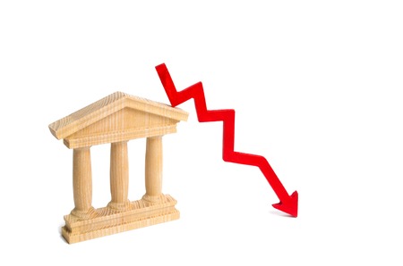 State building and a red arrow down. The concept of the fall in the efficiency of the state, the fall of the economy and sovereignty. Sanctions. Distrust of the government. Bankruptcy of the bank.の写真素材