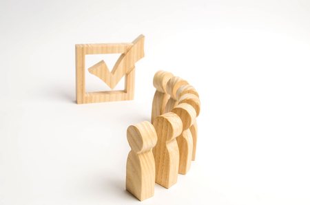 Wooden human figures stand in a row next to government building in the box. Concept of elections and social technologies. Volunteers, parties, candidates, constituency electorates. Selective focusの写真素材