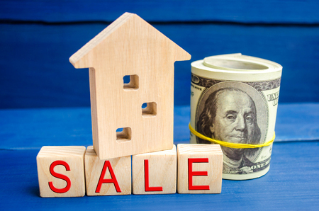 wooden house on a blue background with the inscription sale. sale of property, home, real estate. affordable housing. place for text. copy spaceの写真素材