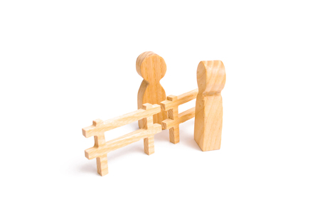A wooden red chart arrow down divides the two people discussing the case. Termination and breakdown of relations, breaking ties. Contract break, conflict of interests. Negotiations of businessmen.の写真素材