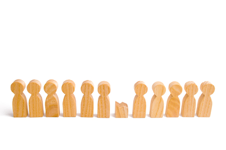 A row of wooden people and a broken figure of a person among them. The concept of a weak link. Did not give up to expectations and did not fulfill the task. Weak player, worker for dismissal.の写真素材