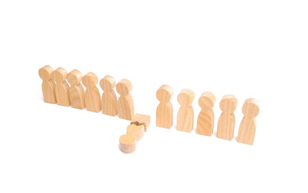 A row of wooden people and a broken figure of a person among them. The concept of a weak link. Did not give up to expectations and did not fulfill the task. Weak player, worker for dismissal.の写真素材