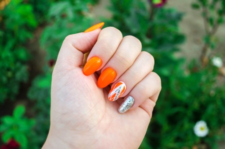 Perfect manicure and natural nails. Attractive modern nail art design. Orange autumn design. Long...