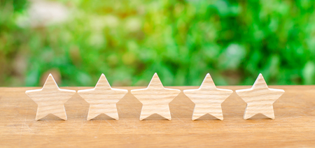 Five wooden stars. Get the fifth star. The concept of the rating of hotels and restaurants, the evaluation of critics and visitors. Quality level, good service.の写真素材