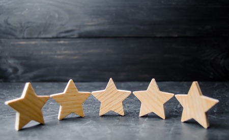 Five wooden stars. Get the fifth star. The concept of the rating of hotels and restaurants, the evaluation of critics and visitors. Quality level, good service. selective focus