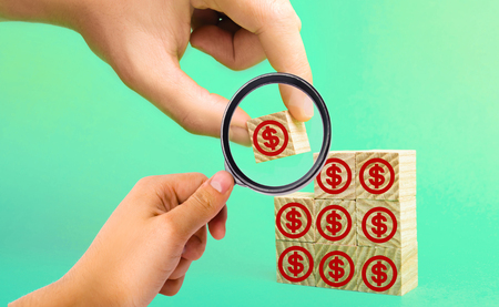 wooden blocks with the image of dollars. concept of investment, investing money in business. increase of capital, payment of a loan, opening of a deposit. businessman's hand.の写真素材