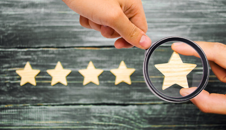 The businessman's hand holds the fifth star. A new star, achievement.The concept of the rating of hotels and restaurants, the evaluation of critics and visitors. Quality level, good service.の写真素材