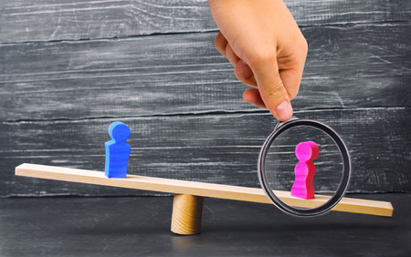 Figures of a man and a woman on the scales. inequality concept : man and women on a weighing balance, gender pay gap. divorce. Division of property in court. Social role in the familyの写真素材