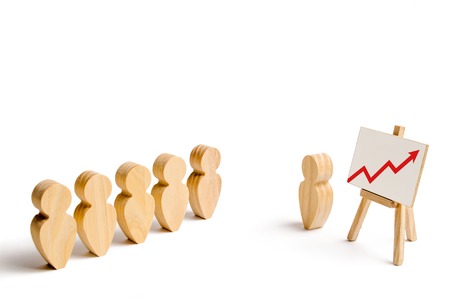 Wooden figures of people stand in the formation and listen to their leader. Business training,...