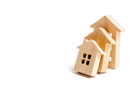 Wooden houses fall on each other like dominoes. The concept of falling prices for house purchase and rent. Poor quality of housing, violation of technology during construction. Selective focusの写真素材