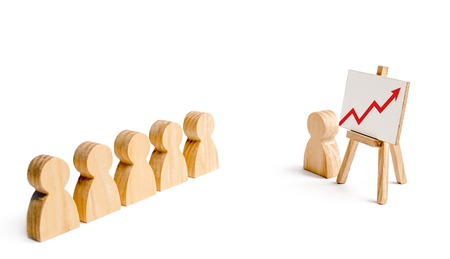 Wooden figures of people stand in the formation and listen to their leader. Business training, briefing and inspirational speech. Summing up, business successes and achievements. Red up arrowの写真素材