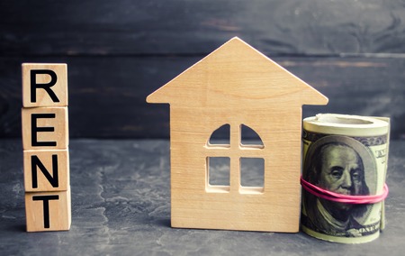 Dollars, wooden house and inscription "rent". Rental of property, apartments. services of a realtor. affordable housing, rental prices. real estateの写真素材