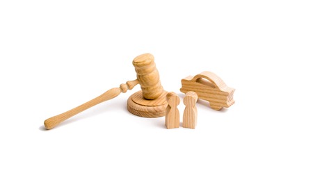 Wooden figurine of a car with people in a hammer of the judge on a white background. Minimalism. Purchase and sale of the car. The trial, confiscation of the machine. Recognition of ownership.の写真素材