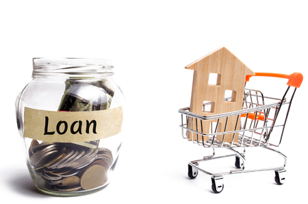 Miniature wooden house and the inscription " Loan ". Buying a home in debt. Family investment in real estate and risk management concept. Loan for a mortgage. apartment rental sale buyの写真素材