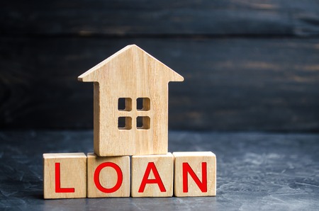 Model of the house and the inscription "Loan". Buying a home in debt. Family investment in real estate and risk management concept. Loan for a mortgage. apartment rental sale buyの写真素材