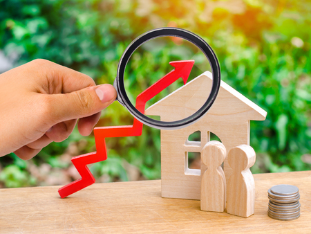 wooden house, money with a red arrow up. concept of high demand for real estate. rise in house prices. population growth. increase in the cost of utilities. property.の写真素材