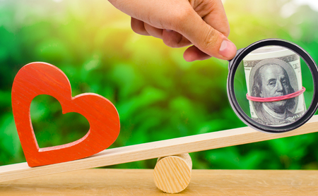 Money versus love concept. Passion versus profit. Family or career choice. family psychology. place for text. wooden figures of people. balanceの写真素材