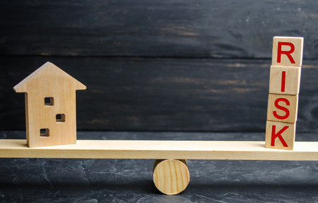 Miniature wooden house and the inscription " Risk " . Buying a house, apartment and financial risks. Loss of property for failure to pay. Property insurance. Mortgage and tax. Real estateの写真素材